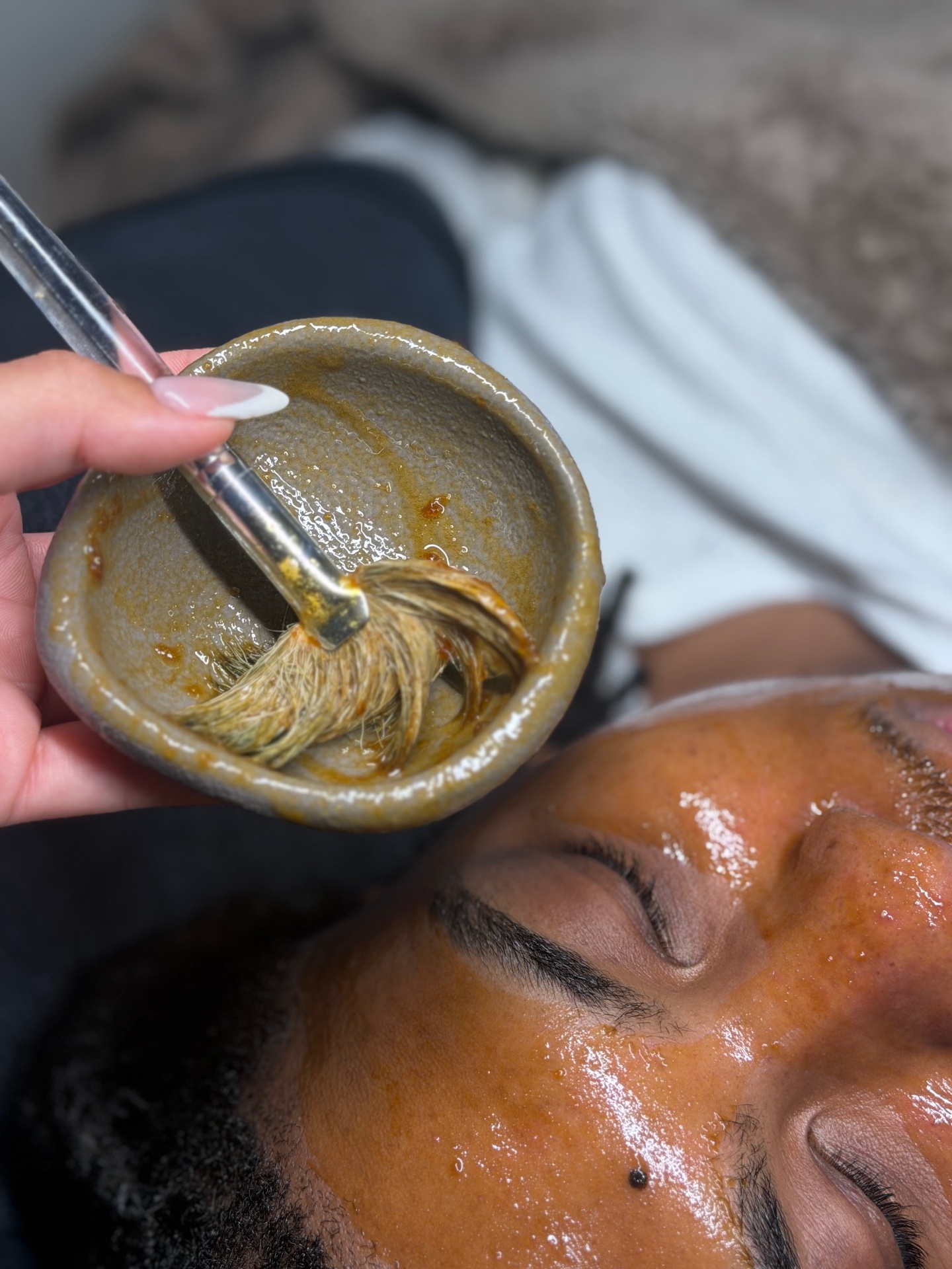 Customized enzyme treatment being brushed onto a client's skin