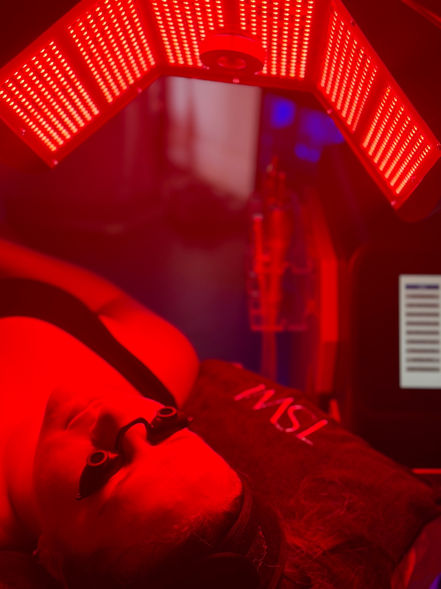 Client under a full body red light therapy panel